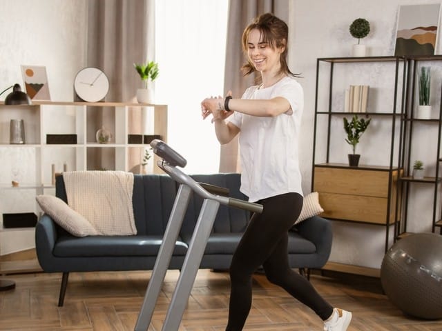 doing exercise by running on the electric treadmill in the fitness room